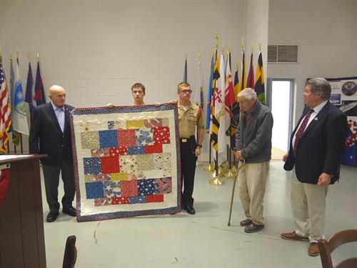 General Williams donating quilt to the museum in front of the President and founding member and JROTC Cadets..