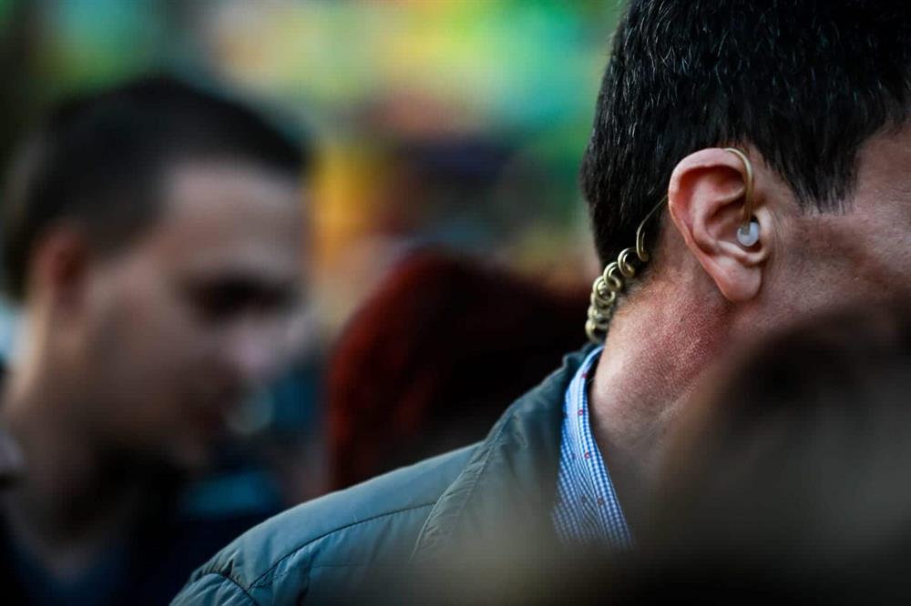 Close protection agent monitoring crowd activity with earpiece communication | Global Risk Solutions, Inc. Close protection agent monitoring crowd activity with earpiece communication | Global Risk Solutions, Inc.