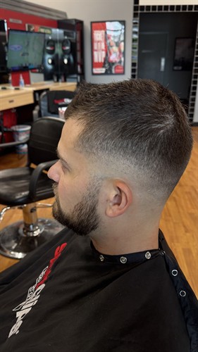 Medium skin fade by Jessica Cash at Sport Clips Haircuts. The blend runs clean from the neckline and tapers around the ear into the length on top.  She finished it with Gibs Grooming Shaping Clay for a nice hold and zero shine.  Walk in for your next precision haircut, or use online check-in on the Sport Clips app or website. You can join the waitlist right away or pick a 30-minute window later the same day. Se habla español.