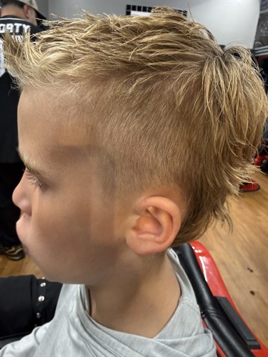 Boys' haircuts done right. This modified mullet, cut by Linette with a clean taper up top, is the kind of back-to-school look every parent hopes for. This is the craft standard at Sport Clips Haircuts of Bradenton, in Manatee County between Chipotle and First Watch at Centre Point Commons. Walk in or check in online. It's a Game Changer.