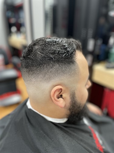 Danny, one of our barbers, created this clean skin fade blended into a natural textured top with a sharp edge around the ear. We're serving South Bradenton and the West Bradenton market from Centre Point Commons on Cortez Rd W, between Chipotle and First Watch, in Manatee County. Walk in anytime or check in online first. Se habla español.