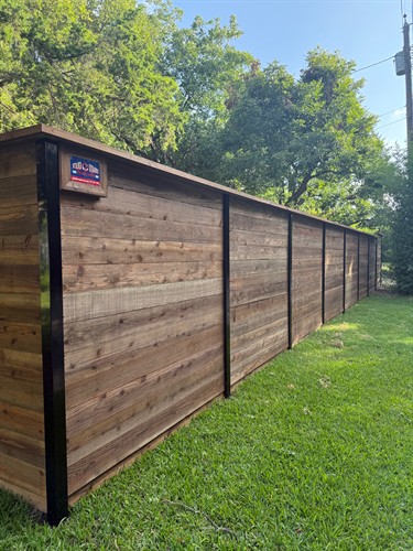6' pre-stained cedar fene in the horizontal style with black square post installed by Stand Strong Fencing of Fort Worth