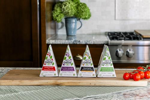 Pictured is our Smoky Gouda, bestselling Un-Brie-Lievable™, Black Garlic, and Artichoke & Herb cashew cheese wedges!