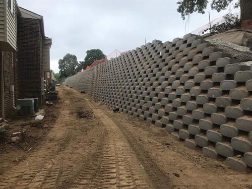 A hercules retains wall behind an apartment complex.