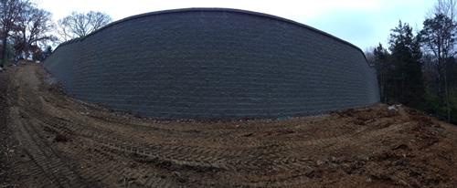 Large retains wall around the back of a house for a new pool.