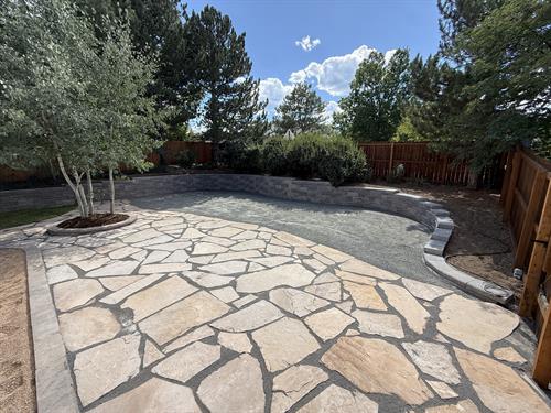 Flagstone patio with a large AB classic retaining wall.