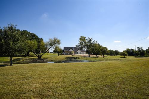 Brenham Farmhouse Design - Exterior Pond & Home - In Progress