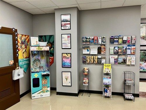 Brochures from places to visit in the Perry area, a claw machine game, and colorful event posters inside the Perry Welcome Center