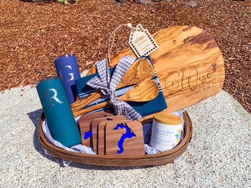 This set is IMPRESSIVE! Includes personalized olive wood cutting board set, custom blue lake coasters, 2 personalized tumblers, and a branded candle. 