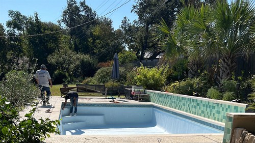 Poolie technicians performing renovation work on the plaster and surface finish of this residential pool.
