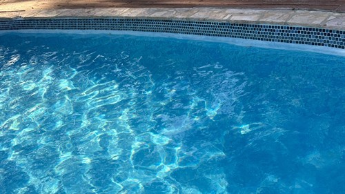 Clear, sunlit water reflects the pool's recent maintenance.