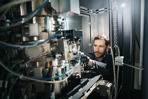 A researcher adjusts precision equipment in a laboratory.