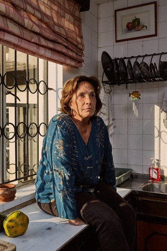 An environmental portrait using window light in a kitchen.