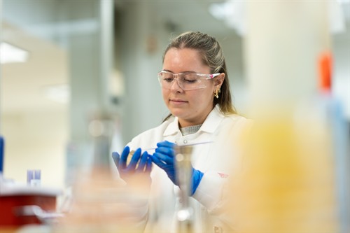 A researcher handles a sample at a laboratory bench.