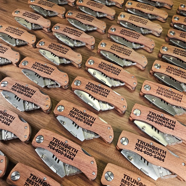 Custom laser engraved wood knives branded with company name and contact number, designed as promotional giveaways for their team and their contractor network.