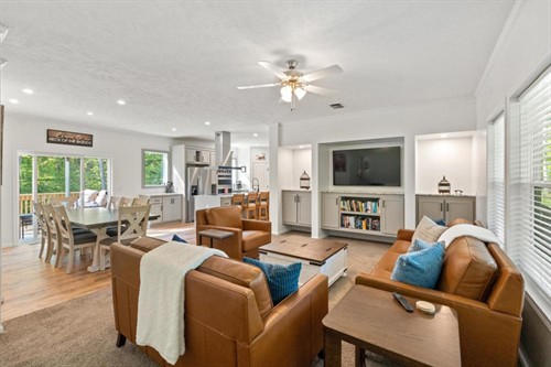 Open great room: leather seating, dining table for eight, kitchen beyond