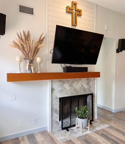 This fireplace face-lift included a custom long mantel, shiplap column above and tiling over existing brick.