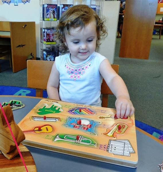 Mariah plays with her Summer Reading Club prize won in the end of summer raffle for Southwest Branch Library