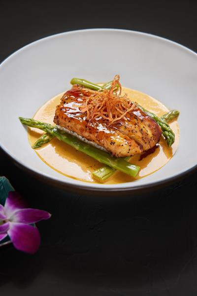 Pan seared  teriyaki glazed fresh snapper over coconut rice, served with fresh asparagus and rich sofrito creme. 
