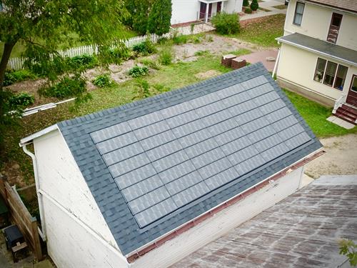 Aerial view of a barn roof upgraded with CertainTeed Landmark Pro shingles and integrated Solstice solar shingles in Evansville. 