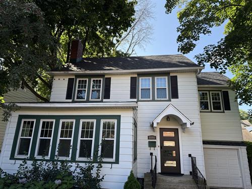 Striking contrast of Moire Black solar shingles against crisp white siding creates a modern look.