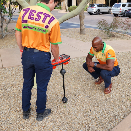 Plumbers are locating exact location of underground sewer pipe.
