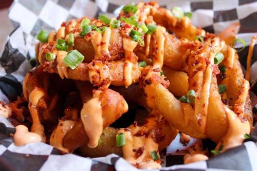Onion Rings drizzled with our homemade Dynamite sauce topped with chopped green onions.
