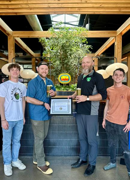 Director Joe Bolick awarding Big Grove Brewery with platinum Iowa Green Brewery Certification