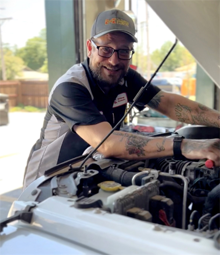 Shop manager, Ben, working under the hood of a customer's car.