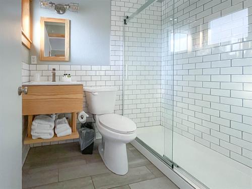 Wanderoom baths feature updated subway tile and walk-in showers
