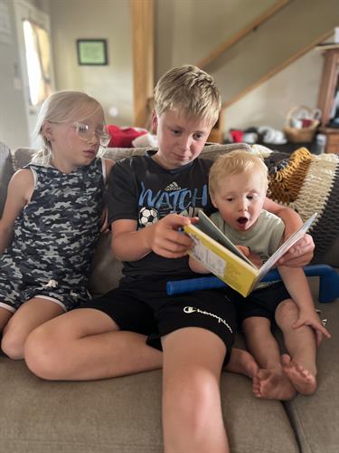 Big brother reads to siblings