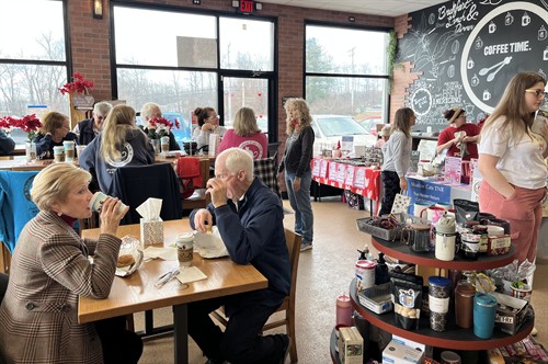 Packed coffee shop scene at The Screaming Bean, where locals meet for specialty coffee and a welcoming community atmosphere.