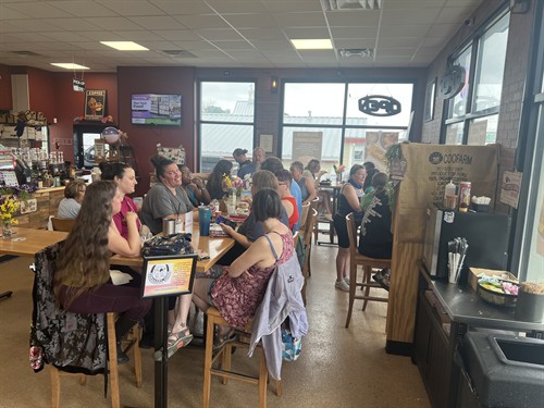 Lively morning rush inside The Screaming Bean coffee shop, showing customers gathering for lattes, breakfast, and conversation in Harford County.