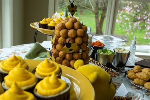 Themed food buffets are so much fun to create and style. This Winnie the Pooh baby shower found guests choosing from Hunny Pot cupcakes and a Beehive made out of donut holes.