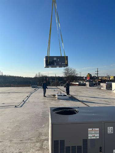 Our crew installing a new HVAC unit for a commercial client