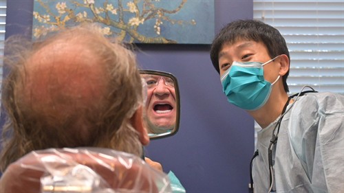 Secure Dental Davenports' Dr. Naru Kang with dental implant patient.
