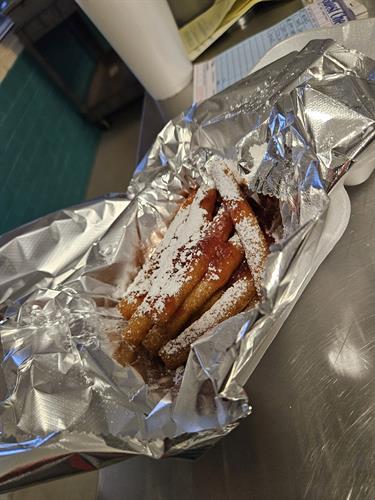 Funnel Cake Fries Topped with homemade strawberry topping and powdered sugar