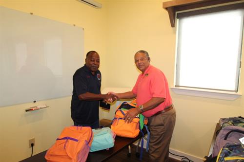 Giving out back to school book bags to children in the community.
