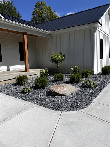 Front yard landscape installation with new plants, and grey slate stone
