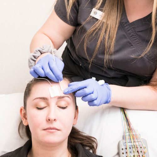 Patient receiving EEG at MIND, with electrodes placed on scalp during neurological testing. 