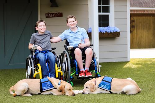 Canine Companions clients, brothers, with their service dogs. 