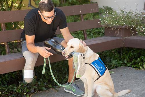 A Canine Companions client, a veteran, working with a Canine Companions service dog on the command, "get," and then "give."