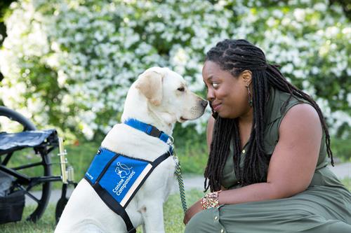 A Canine Companions client cuddling up to her matched Canine Companions service dog. 