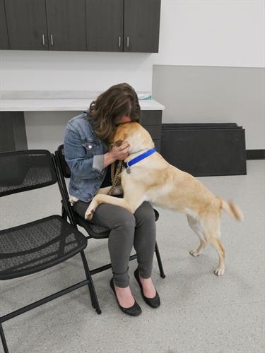 A Canine Companions client giving love to her newly matched Canine Companions service dog .