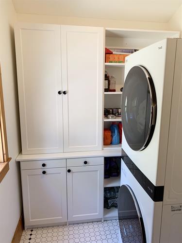 This laundry room has both closed and open storage.