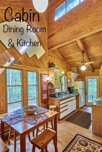 Cabin dining & kitchen with view to back porch, deck & glorious woods. 