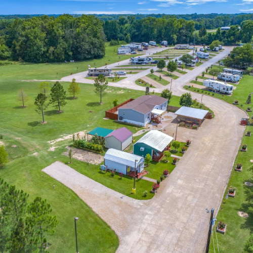 Aerial view of Wagon Train RV Park – spacious layout, wide pull-through roads, and full hookup sites surrounded by greenery.