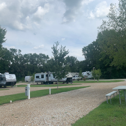 Big-rig friendly pull-through RV sites with green space and shade for both short-term and long-term stays.