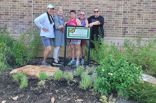 Club members weed the Visitor Center butterfly garden