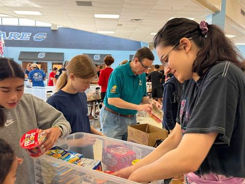 Members and youth programs packing food. 